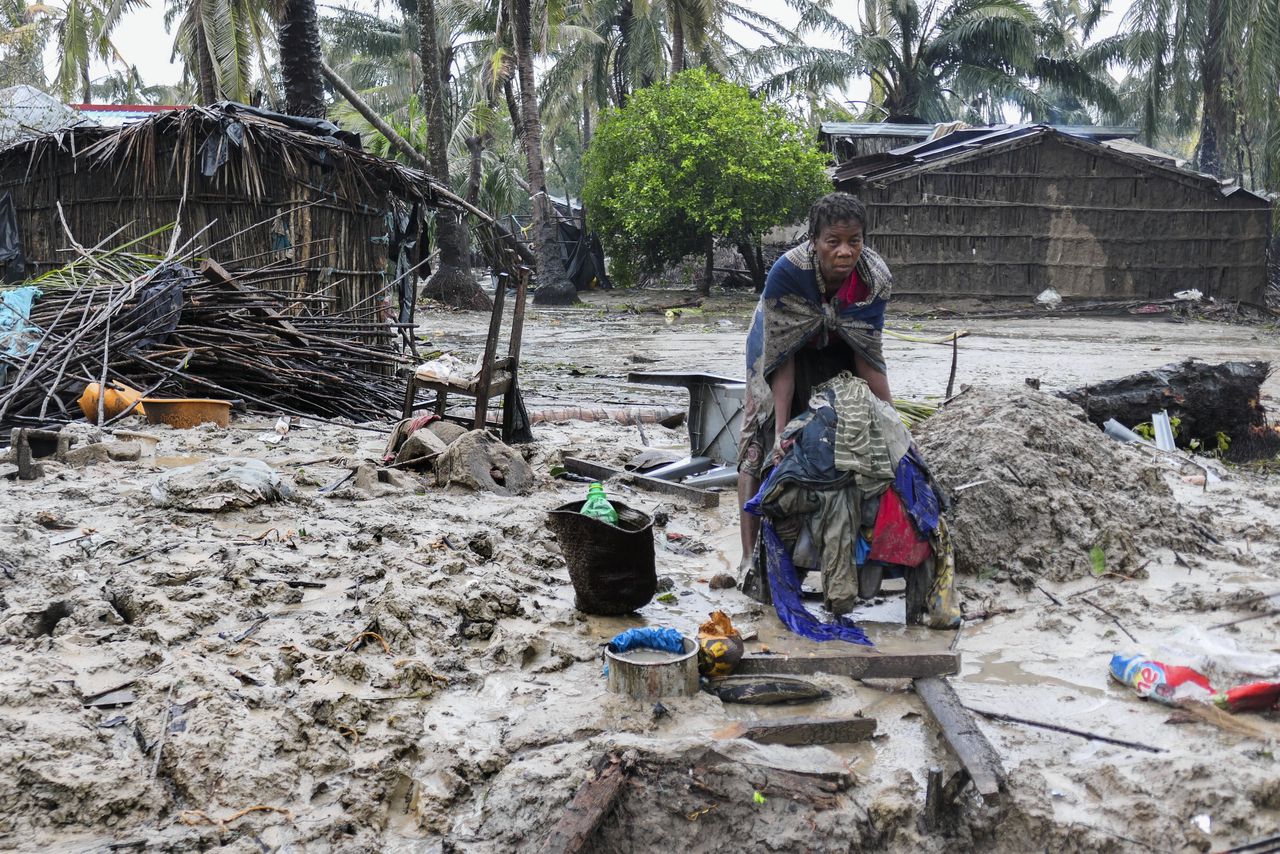 Een vrouw in het Mozambikaanse Quelimane verzamelt een paar kledingstukken die de storm hebben overleefd.