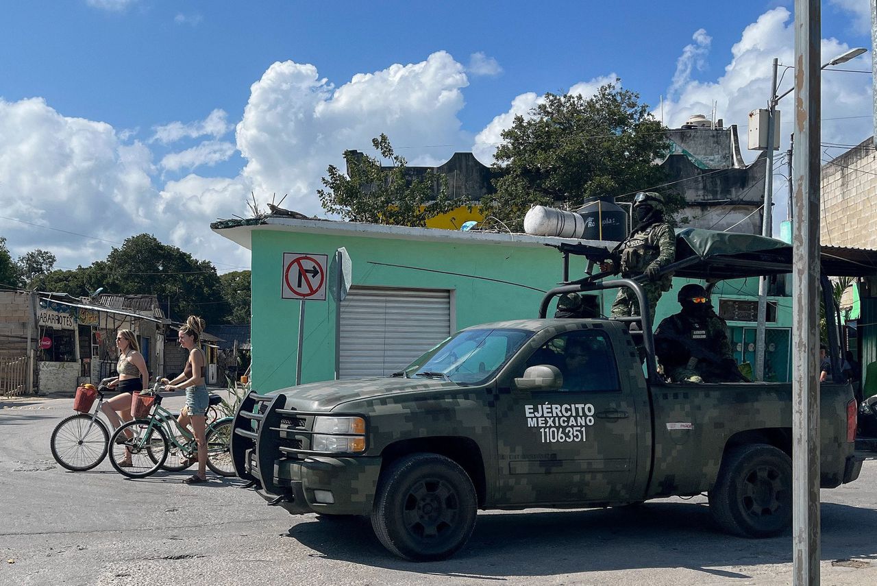 Toeristen in Tulum peddelen naar het strand, terwijl het leger patrouilleert. Foto AFP