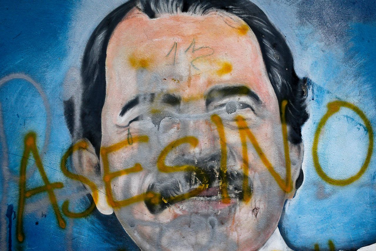 Een muurschildering van de Nicaraguaanse president Daniel Ortega, waar iemand met graffiti het Spaanse woord voor 'moordenaar' op heeft geschreven.