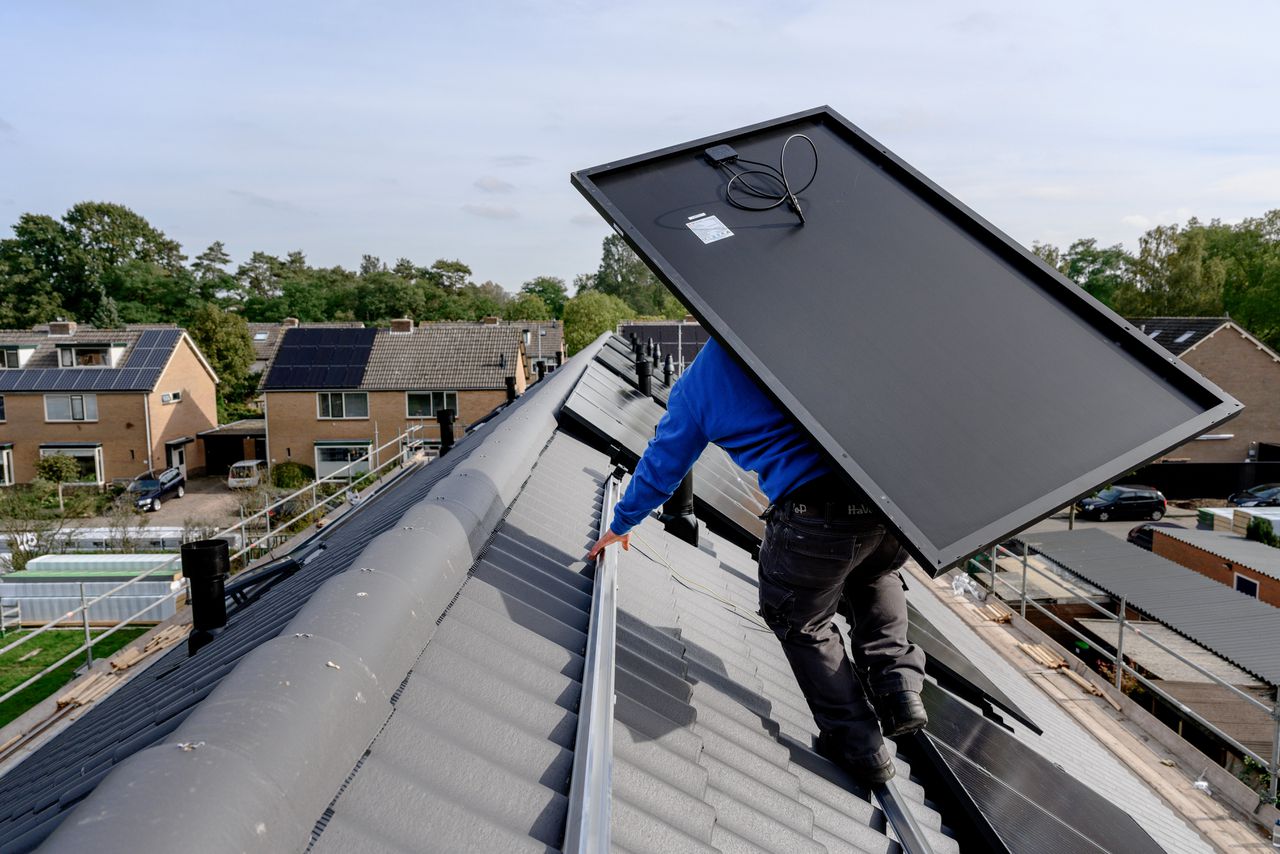 Een installateur van zonnepanelen aan het werk in Ermelo.