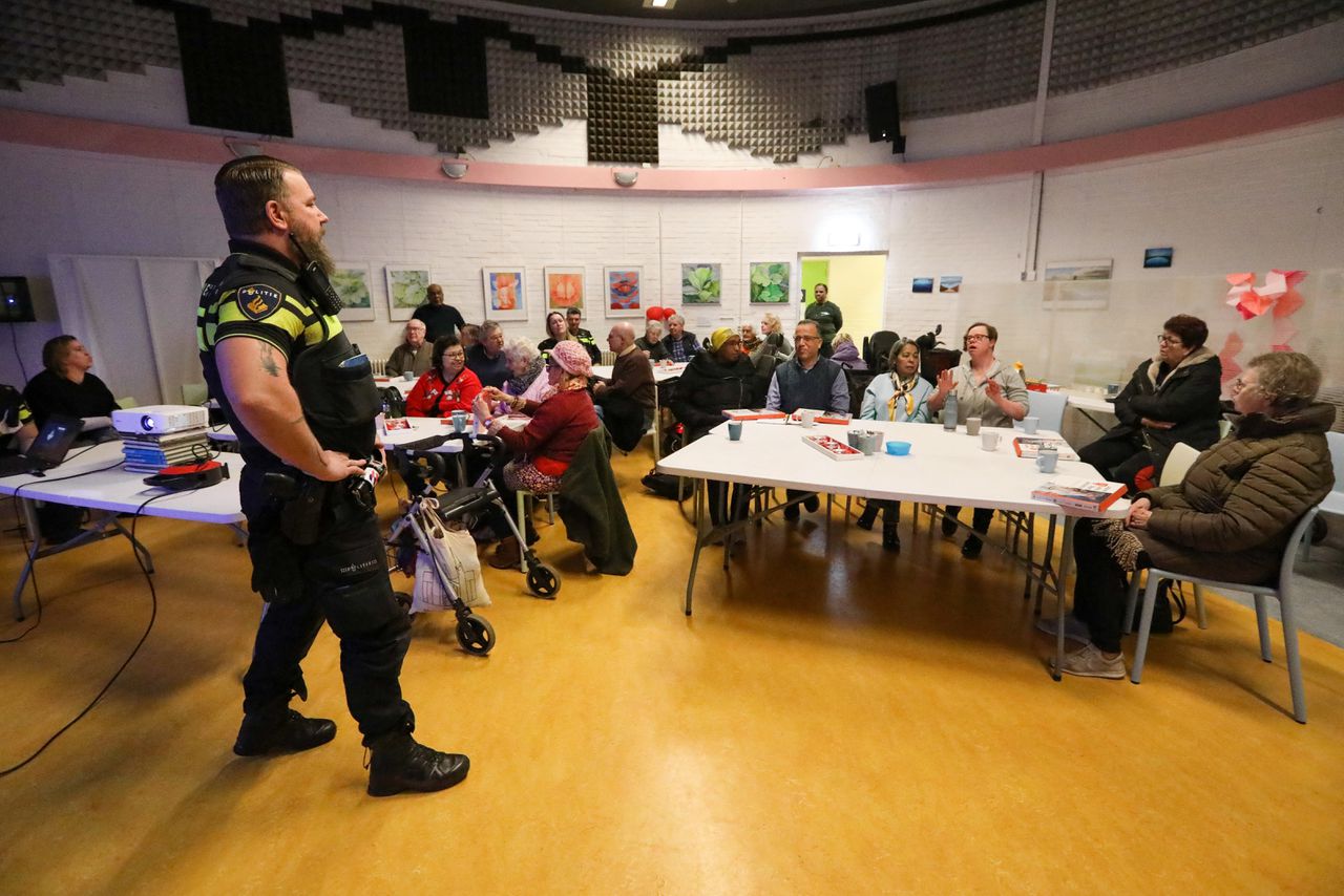 Wijkagent Theo Denie informeert ouderen over babbeltrucs, in Huis van de Wijk in Ommoord, Rotterdam.