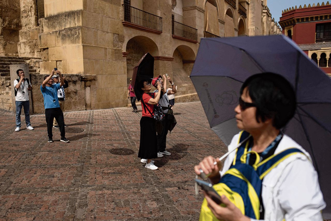 Toeristen in Córdoba beschermen zich met paraplus tegen de directe zon. In de zuidelijke stad zou de temperatuur vrijdag en zaterdag de veertig graden kunnen bereiken.