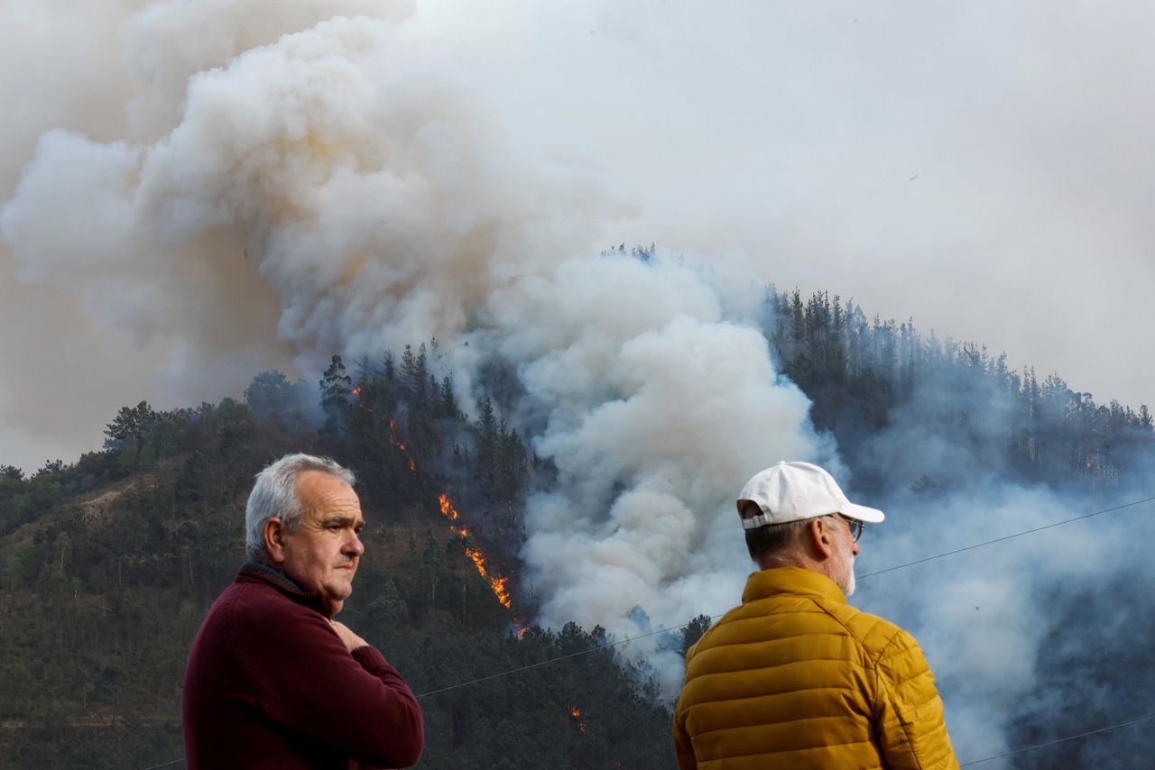 Bezorgde bewoners in de buurt van een bosbrand in Setienes, in de Spaanse regio Asturië.