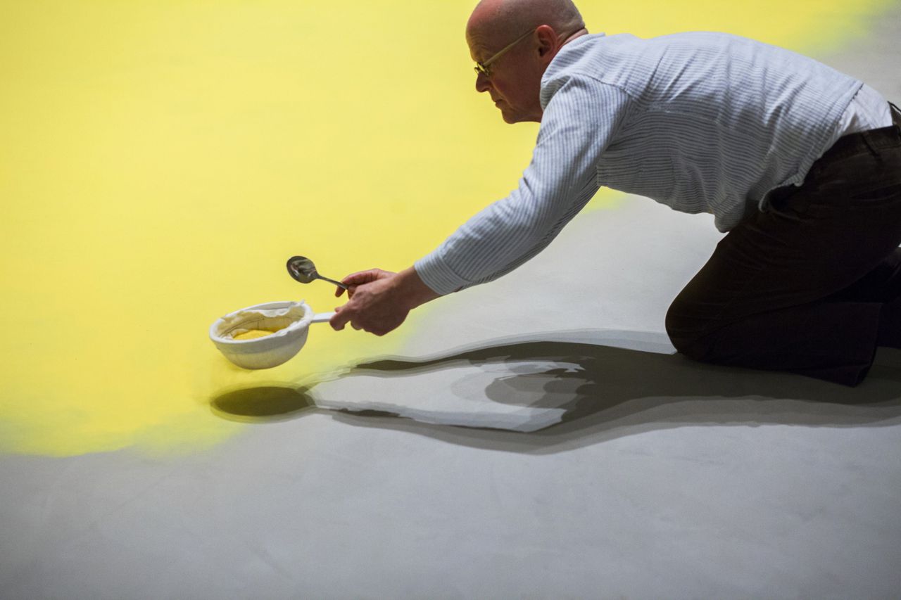 De kunstenaar Wolfgang Laib aan het werk in het Museum of Modern Art in New York. Hij werkt hier met pollen van de hazelaar.