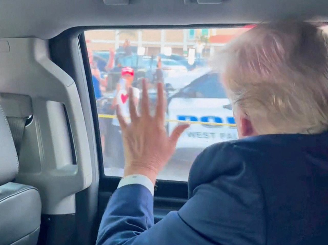 Oud-president Donald Trump zwaait de menigte toe op weg naar zijn residentie in Florida, nadat hij de aanklacht in Manhattan heeft aangehoord.