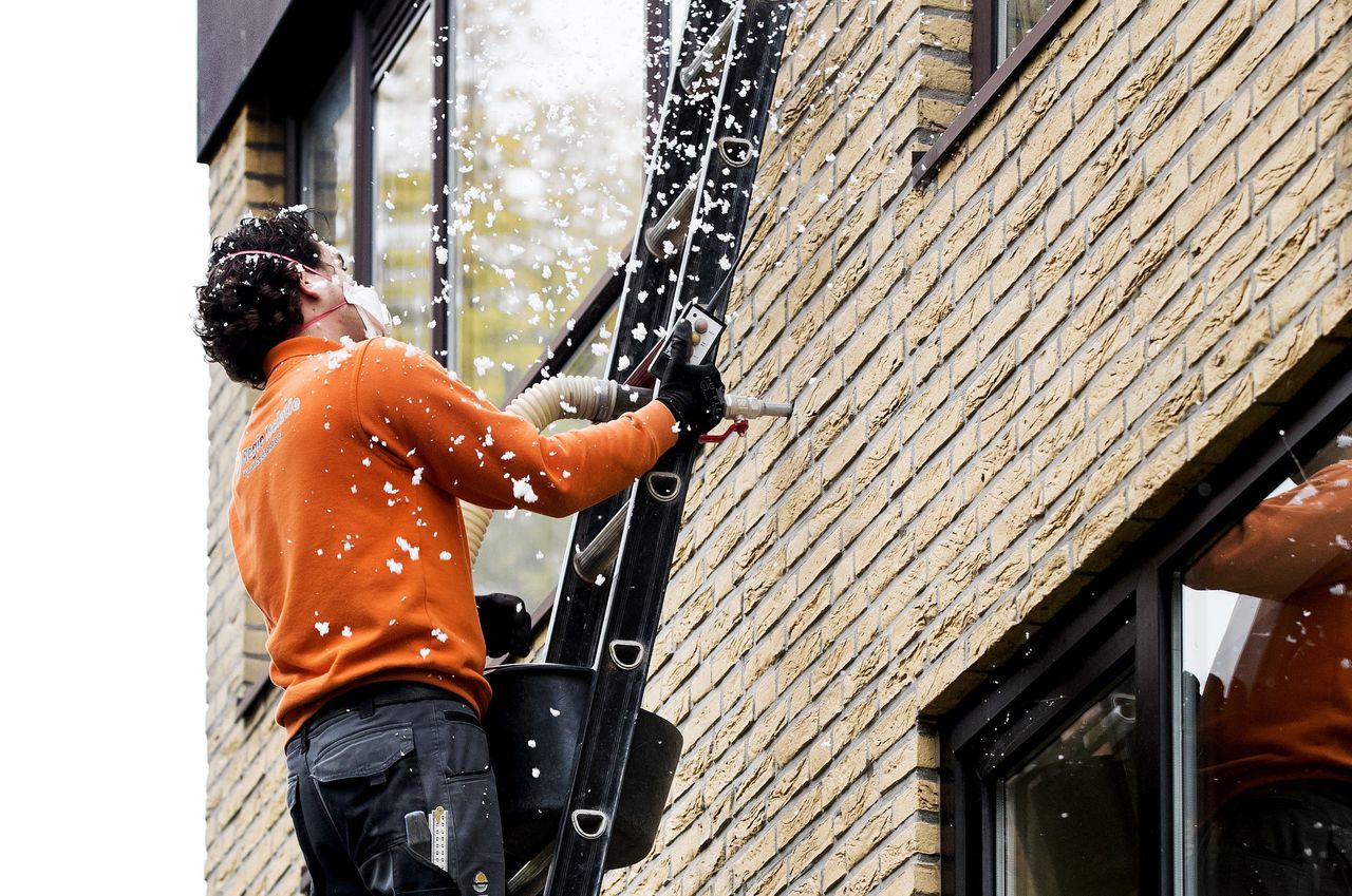 Isoleren van een woning door vullen van de spouw.