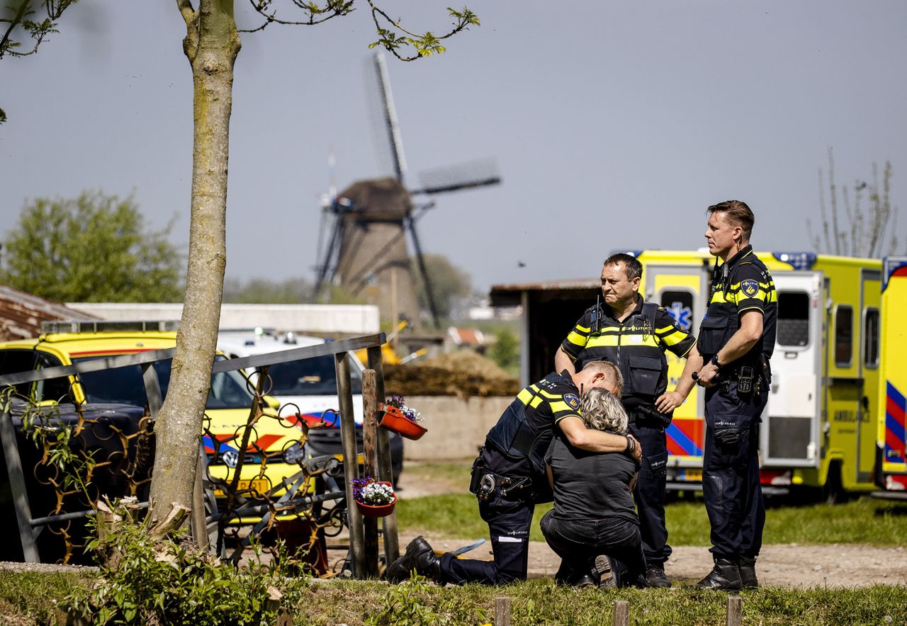 Een vrouw wordt getroost door een politieagent bij de zorgboerderij in Alblasserdam waar slachtoffers vielen door schutter John S., op 6 mei 2022.