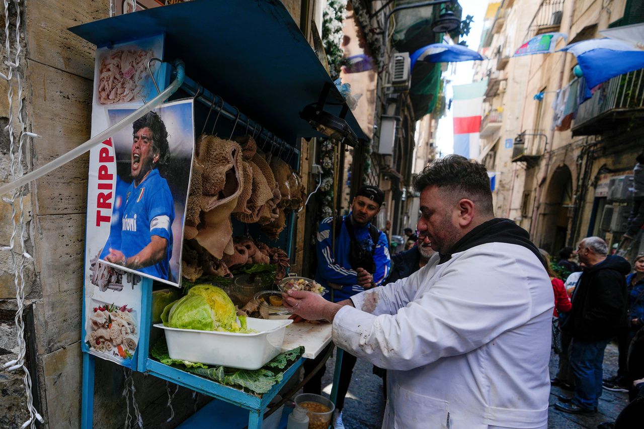 Een foto van Diego Maradona hangt aan het stalletje van een slager in een straat in Napels. Maradona speelde van 1984 tot 1992 bij SSC Napoli.