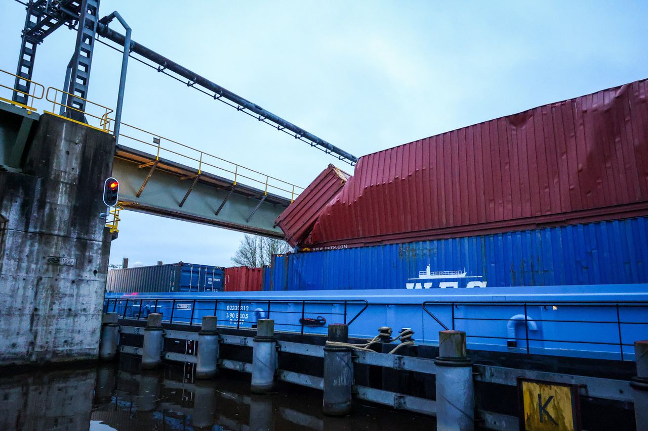 Een binnenvaartschip volgeladen met containers heeft vrijdagochtend vroeg de lage spoorburg in Gouda geramd.