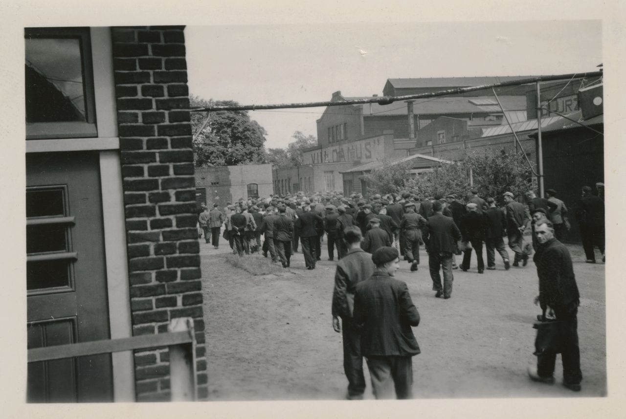 Werknemers van ijzergieterij Vulcanus in Vaassen lopen in 1943 massaal de poort uit.