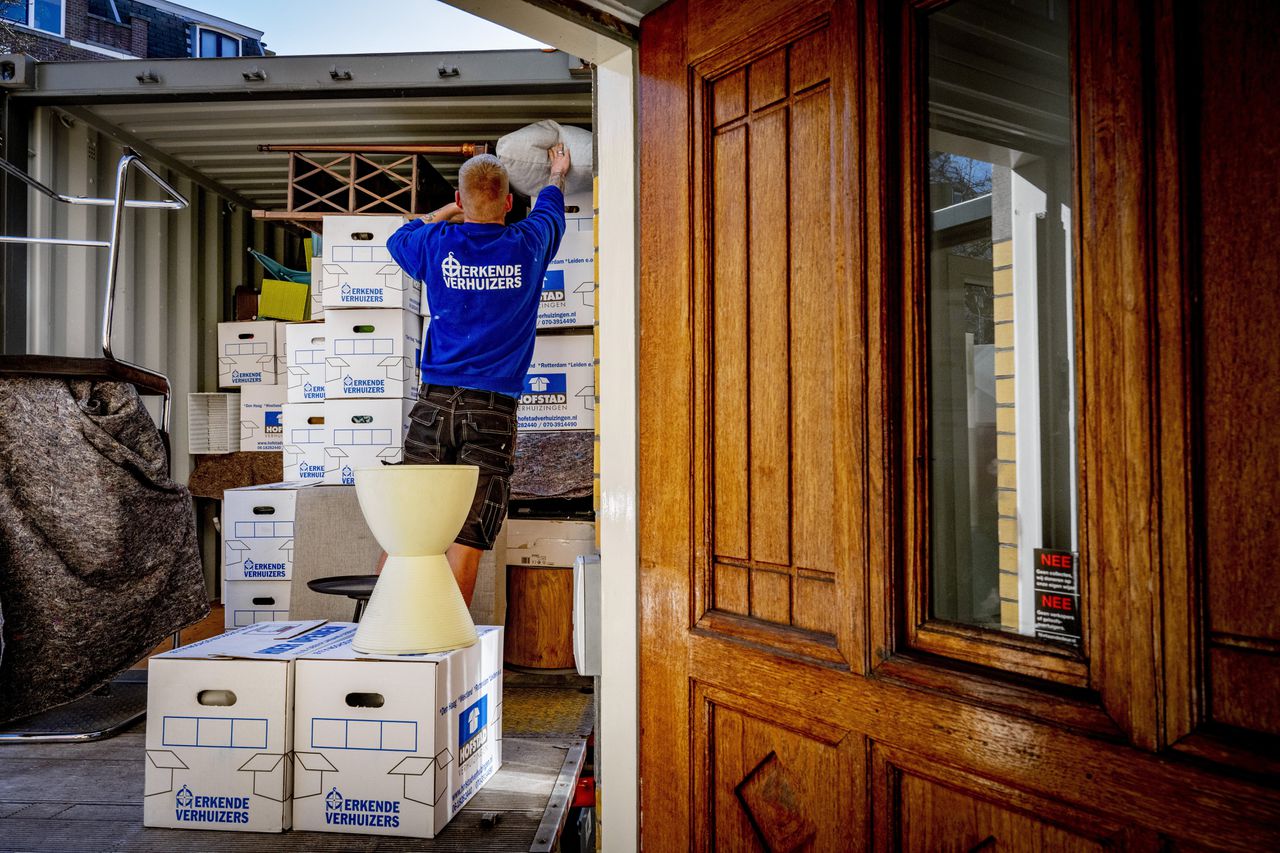 Verhuizers halen een huis leeg dat is verkocht. Huizen zijn goedkoper geworden, nu de rente snel is gestegen.