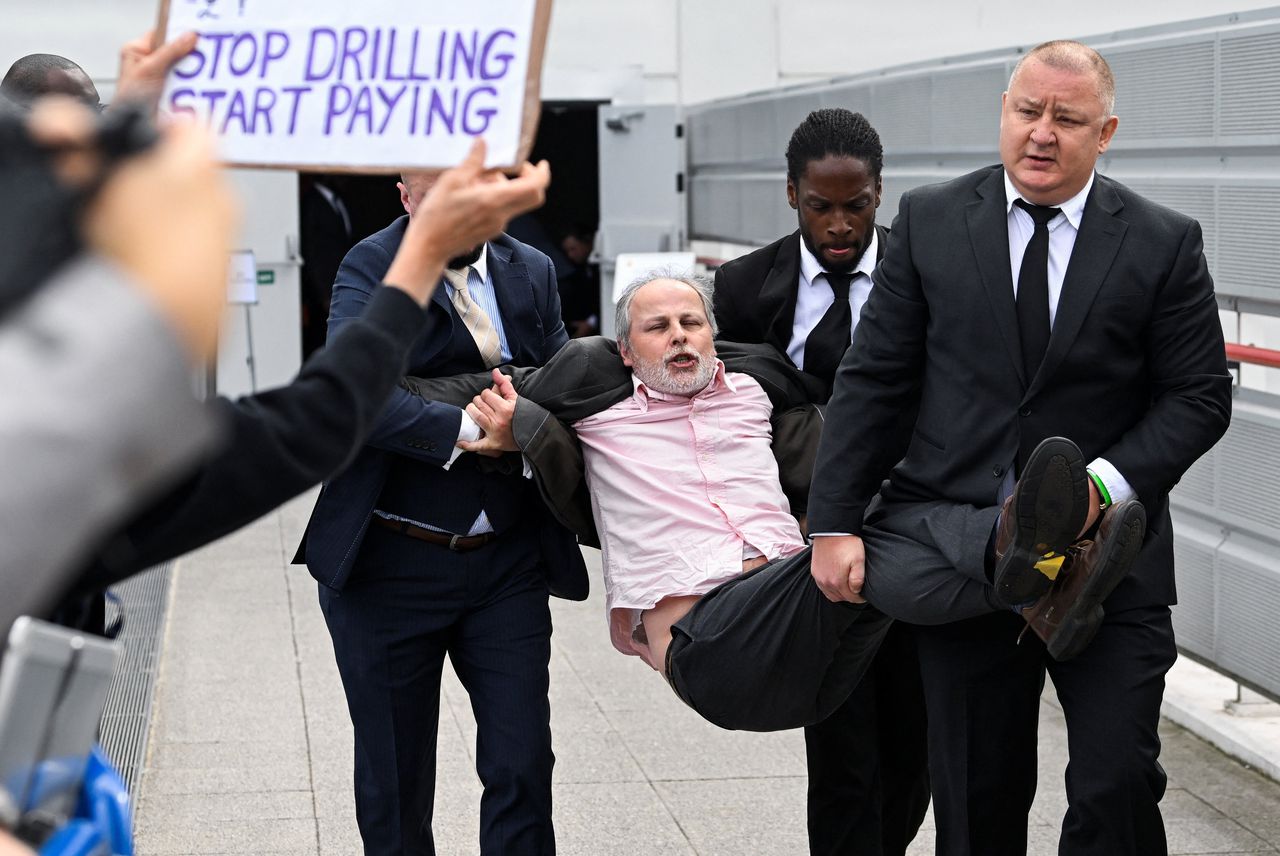 Beveiligers halen een demonstrant weg bij de jaarlijkse aandeelhoudersvergadering van Shell in Londen.