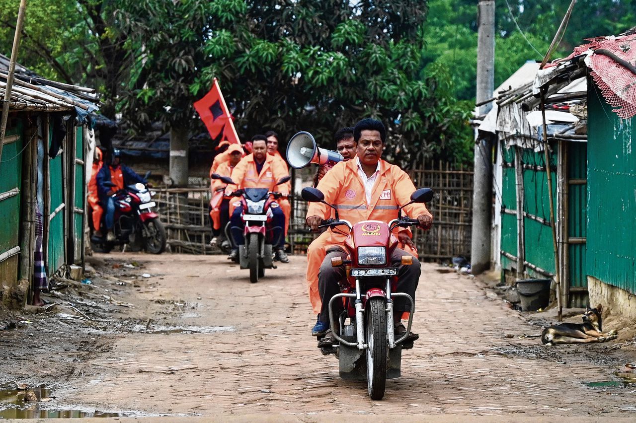 Met een megafoon en rode vlaggen waarschuwen reddingswerkers inwoners van het Nayapara-vluchtelingenkamp in Bangladesh voor het gevaar van de naderende orkaan.