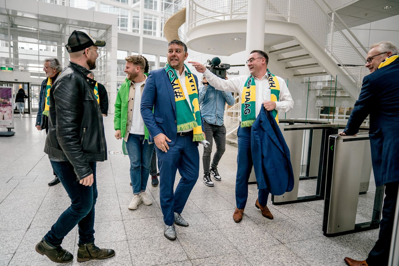 Oud-wethouders Rachid Guernaoui (colbert aan) en Richard de Mos (colbert uit) worden bij het Haagse stadhuis verwelkomd door partijgenoten.