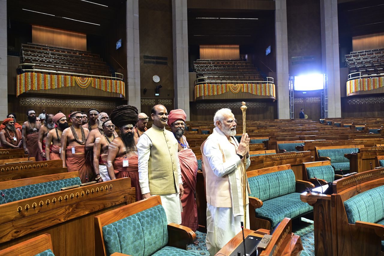 De Indiase premier Narendra Modi draagt ​​een gouden scepter het parlement in bij de openingsceremonie van het nieuwe parlementsgebouw.