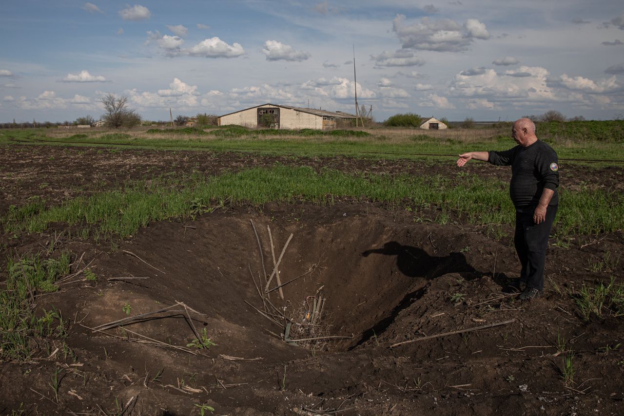 Boer Volodymyr Altsjejev laat een krater zien, die een Russisch projectiel heeft geslagen in zijn grond in de regio Donetsk, niet ver van het front.