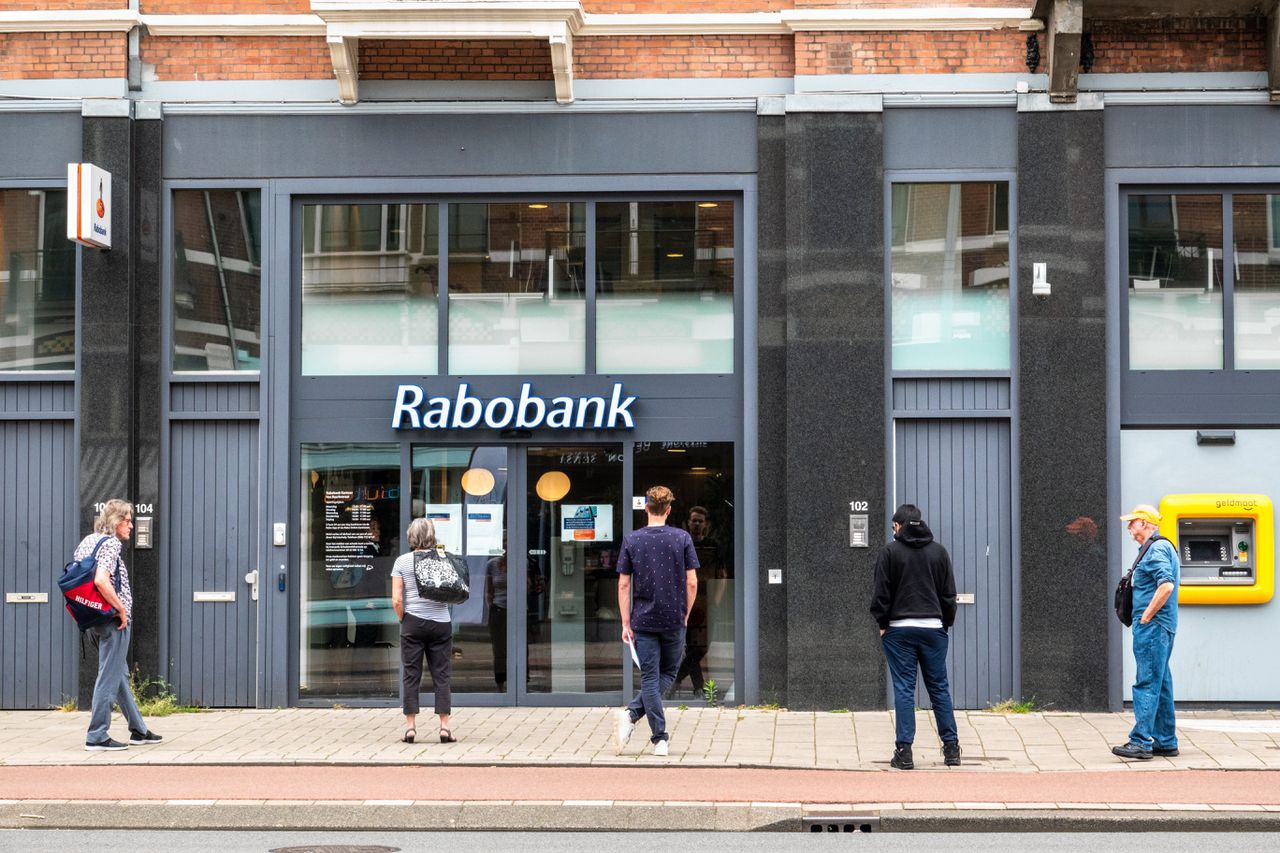 Klanten wachten voor het Rabobankfiliaal in de Van Baerlestraat in Amsterdam.