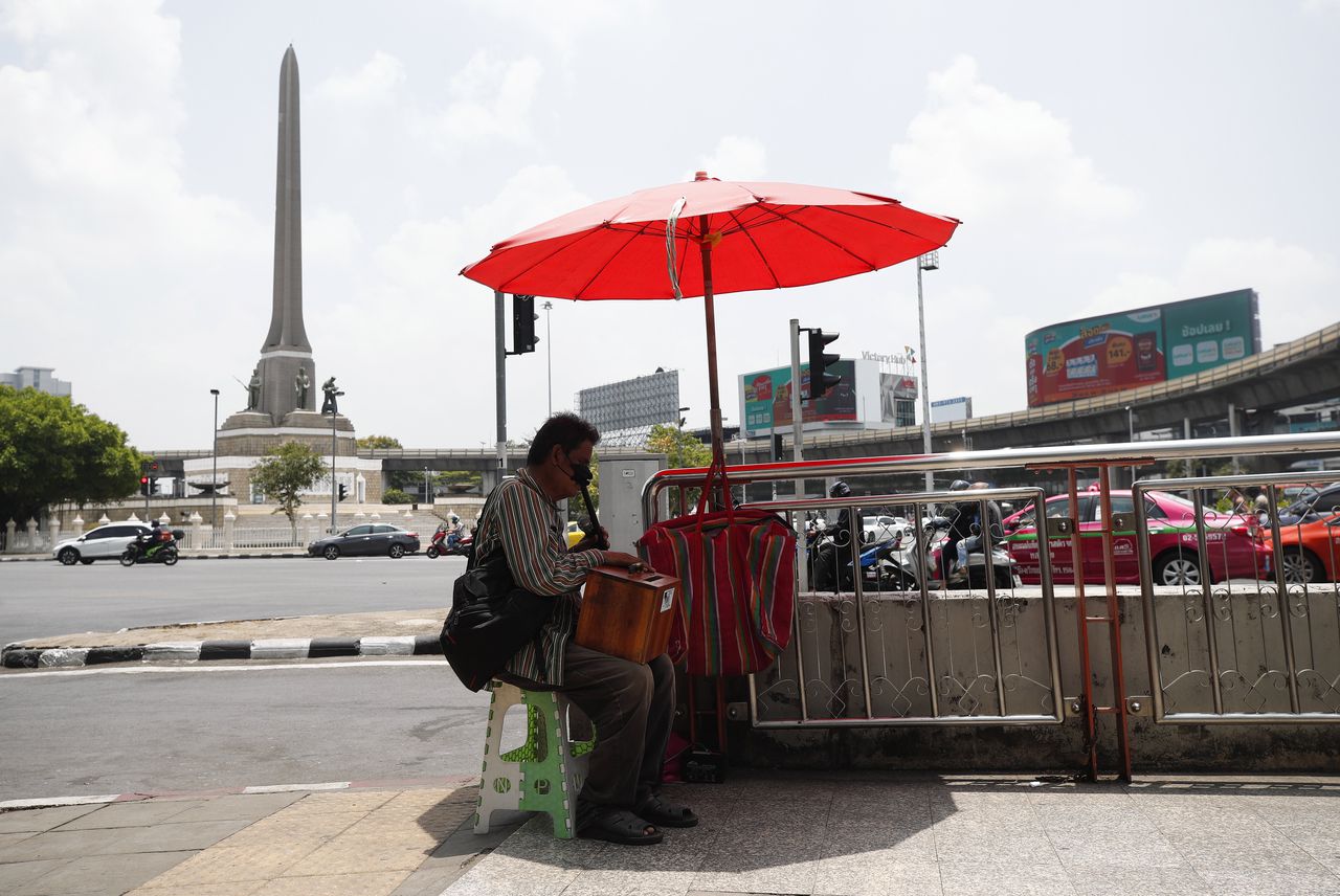 Een man zoekt de schaduw op in Thailand. Daar was het afgelopen week extreem heet, boven de 44 graden.