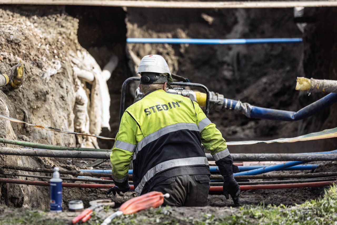 Een medewerker van Stedin legt kabels in Den Haag.