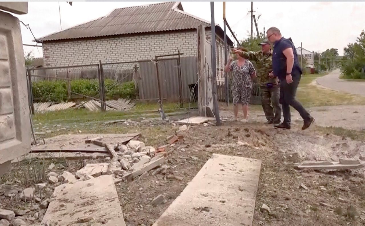 Mensen bij een beschadigd gebouw in de Russische regio Belgorod, op een beeld uit een video na de aanval op het gebied op maandag.