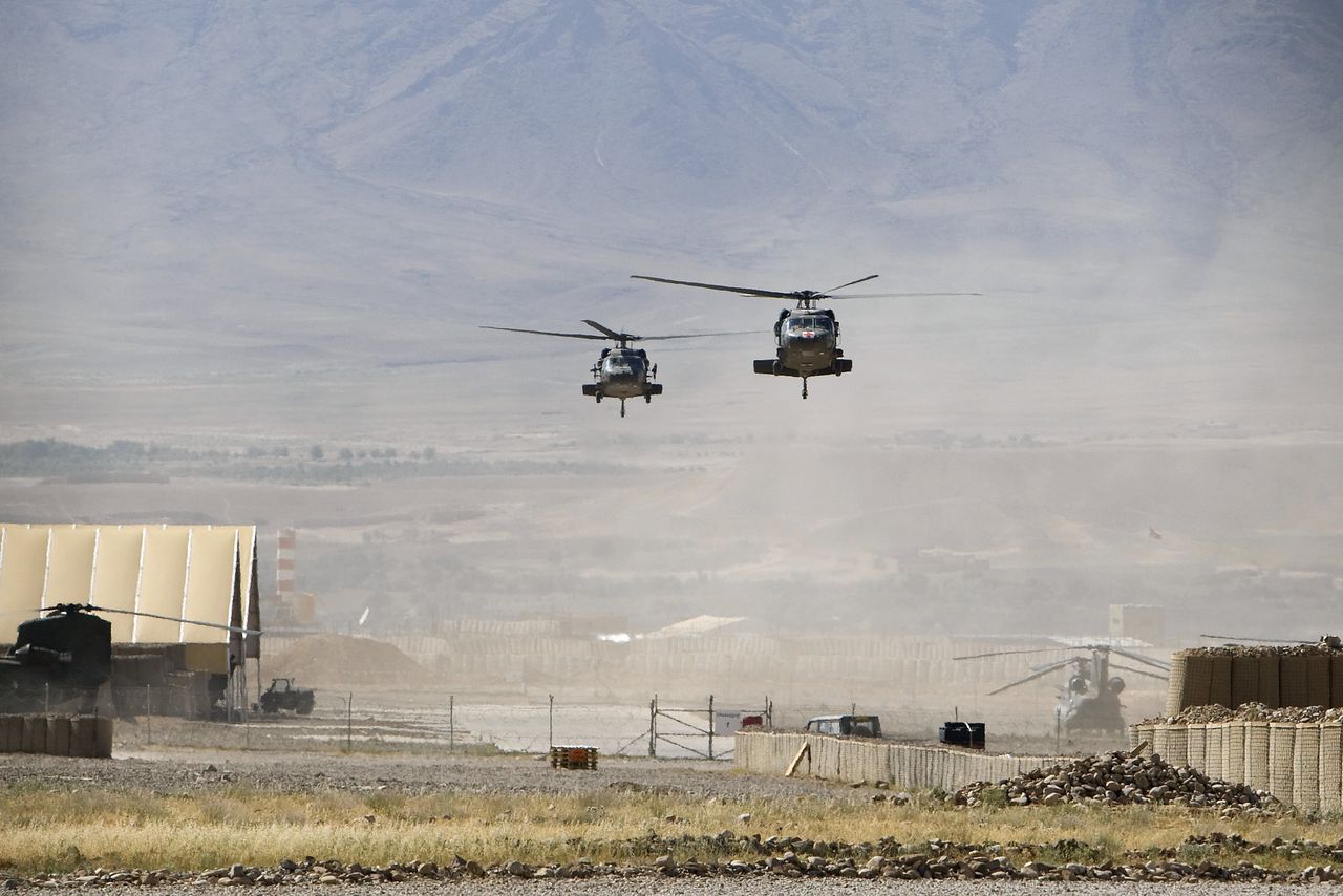 Helikopters landen op een Afghaans vliegveld om twee Nederlandse gewonden op te halen voor vervoer naar Kandahar.
