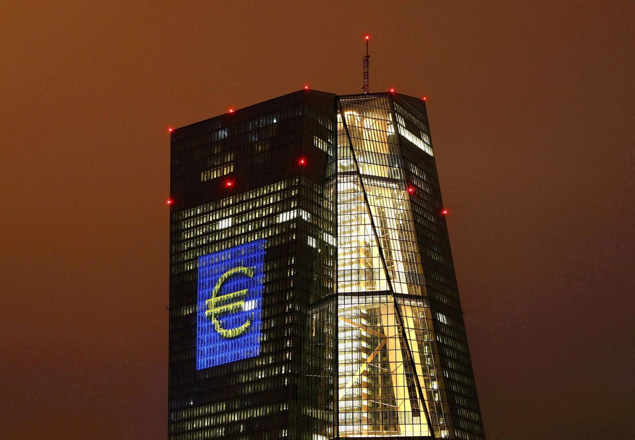 Het hoofdkantoor van de Europese Centrale Bank in Frankfurt verlicht met een euroteken.