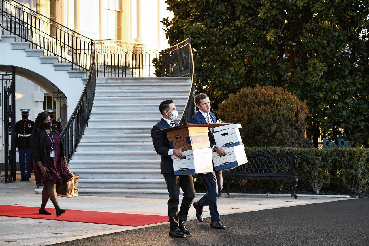 Personeel van president Trump met dozen bij zijn vertrek uit het Witte Huis.