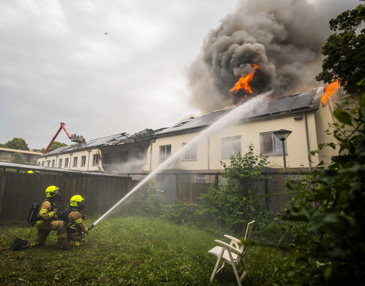 Dat het vuur nog niet onder controle is, komt doordat het bluswater niet goed bij de huizen kan komen door zonnepanelen op de daken.