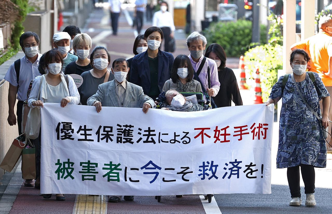 Sympathisanten van de Japanse Sumiko Nishi (in de rolstoel) onderweg naar de rechtbank in Tokio in september vorig jaar. Nishi eist schadevergoeding voor de gedwongen sterilisatie die ze onderging als kind.