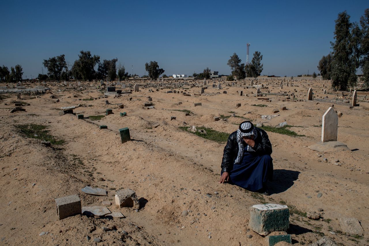 Abdallah Rashid Saleh (51) knielt bij de graven van zijn familieleden in Hawija, februari 2023.