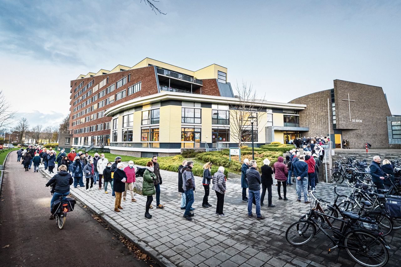 Lange wachtrij voor een griepprik in Assen. Griep en verkoudheid waren de meest voorkomende oorzaken van ziekmelding, gevolgd door psychische klachten.