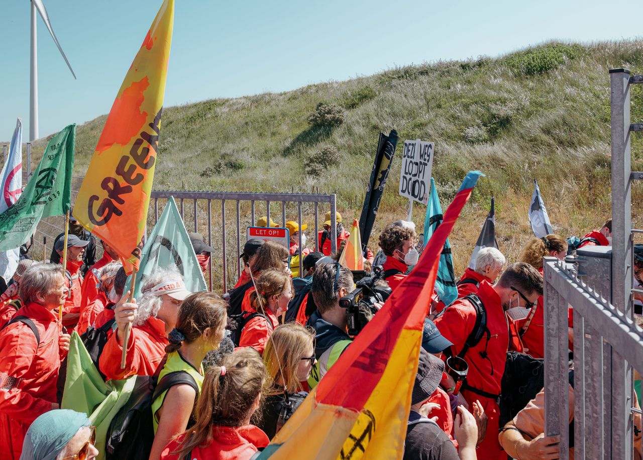 Demonstranten van Greenpeace breken door het hek aan de rand van Tata Steel.