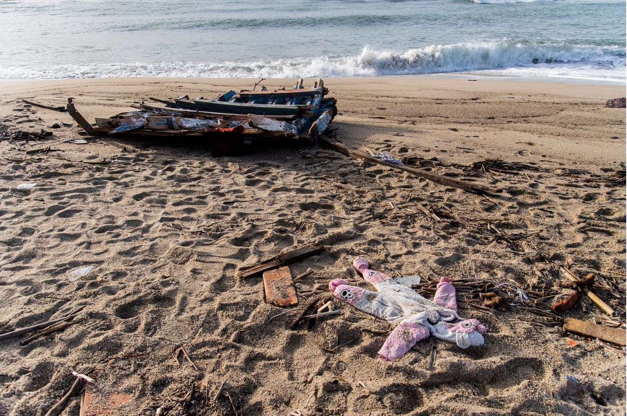 Wrakstukken en kinderkleding op het strand bij het Italiaanse Crotone, na de ramp met een vluchtelingenboot die 96 migranten het leven kostte.