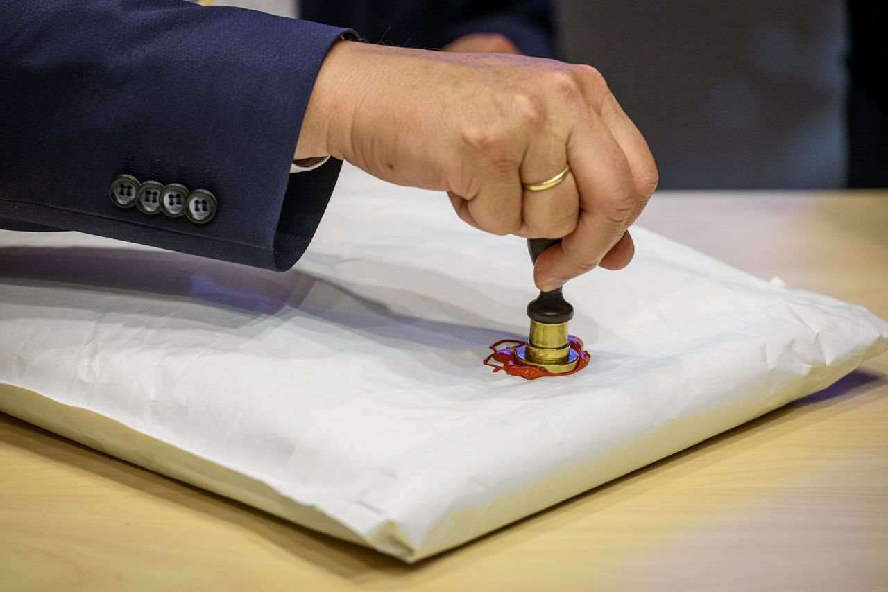 Commissaris van de koning Overijssel, Andries Heidema, plaatst een stempel op de envelop met stemmen voor de Eerste Kamerverkiezingen.