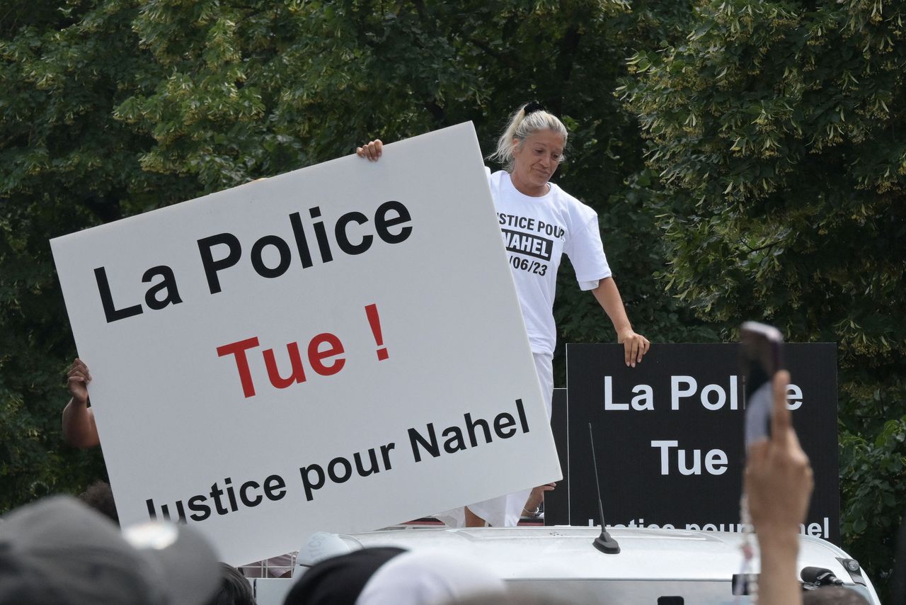 Mounia, de moeder van de doodgeschoten Nahel M., houdt bij een witte mars op donderdag in Nanterre een bord vast met de tekst ‘De politie doodt! Gerechtigheid voor Nahel’.