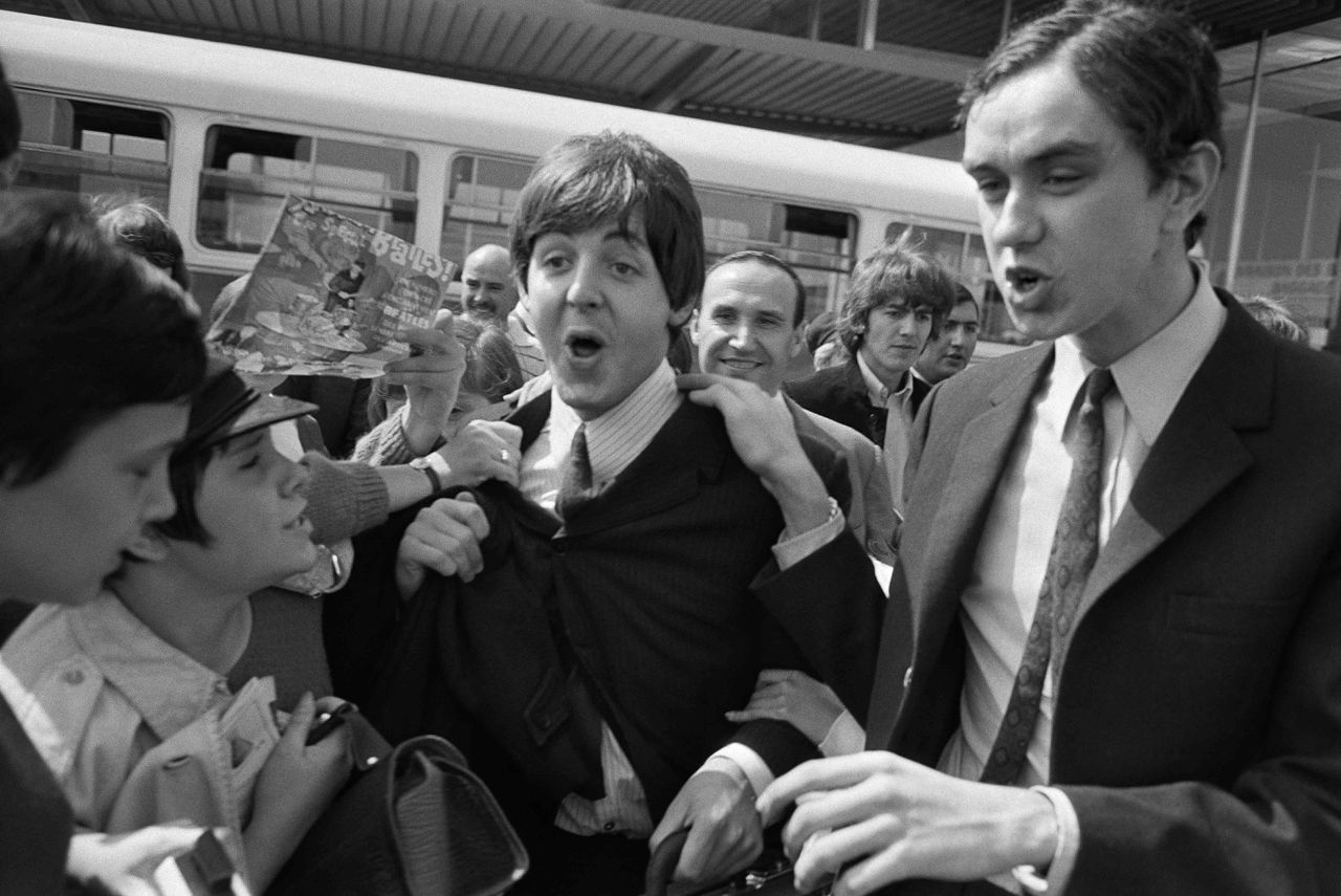 Paul McCartney en George Harrison worden in 1965 door Fans ontvangen op het Franse vliegveld Orly.