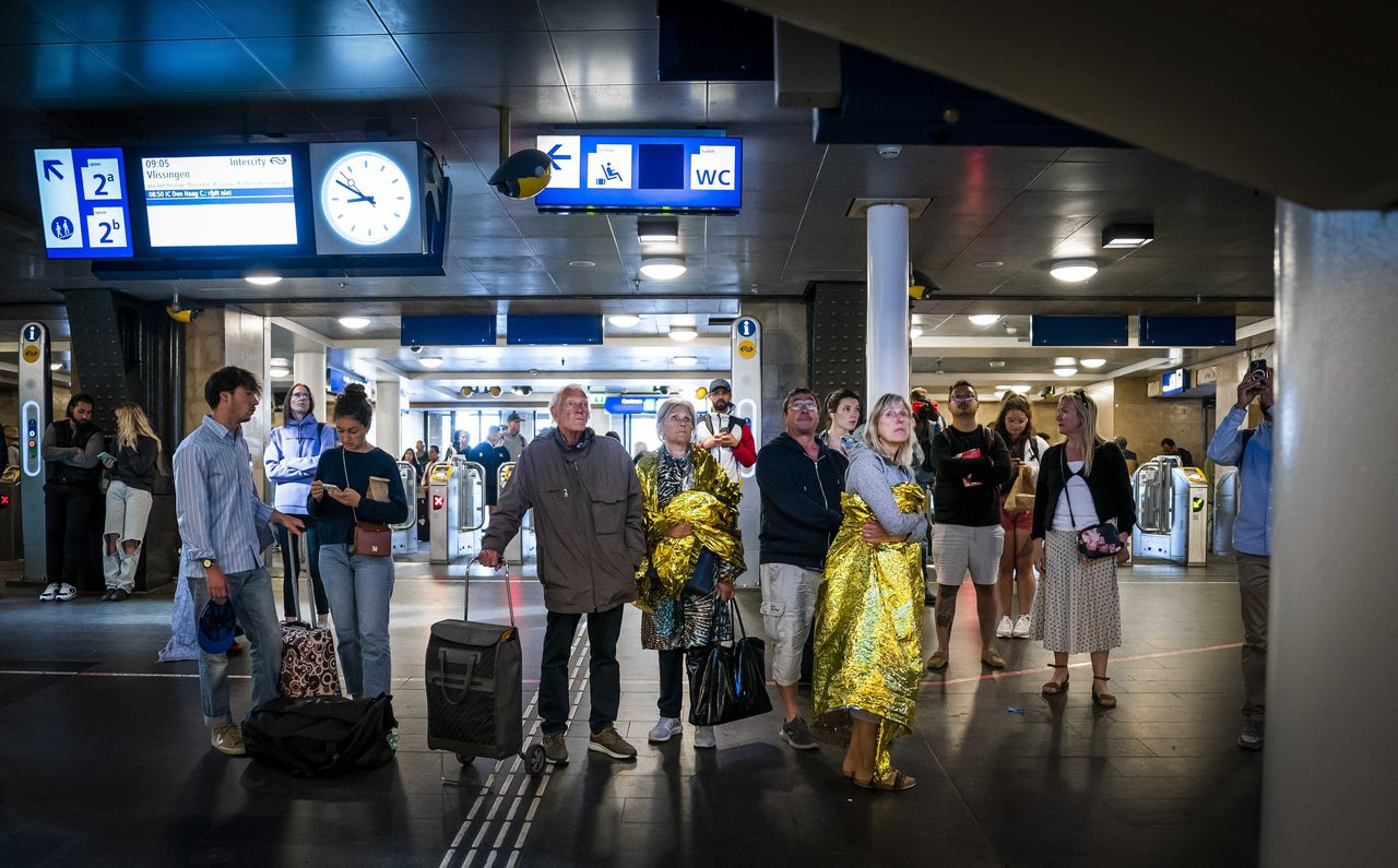 Reizigers wachtten tevergeefs op een trein op station Amsterdam Centraal, waar door een storing geen treinverkeer mogelijk was.