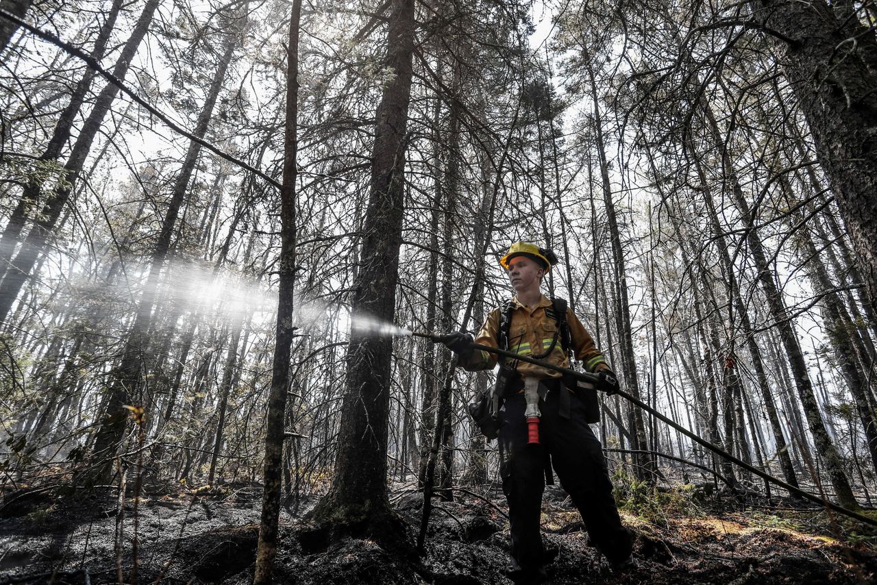 Een brandweerman in Nova Scotia in de oostelijke Canadese provincie Nova Scotia probeert de natuurbrand te bestrijden.