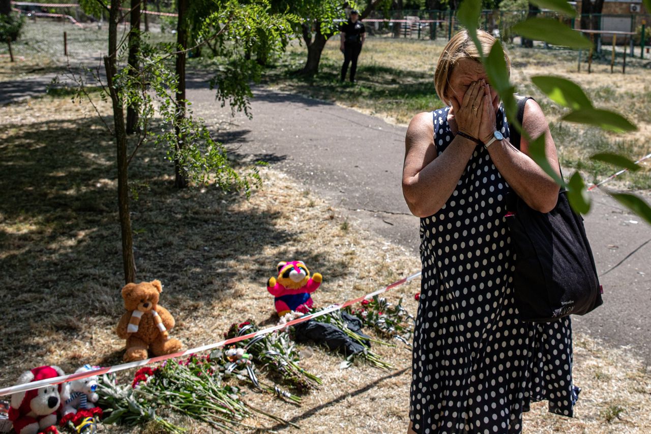 Mensen leggen bloemen en beertjes neer bij de plek in Kyiv waar woensdagnacht drie mensen omkwamen tijdens een Russische luchtaanval.