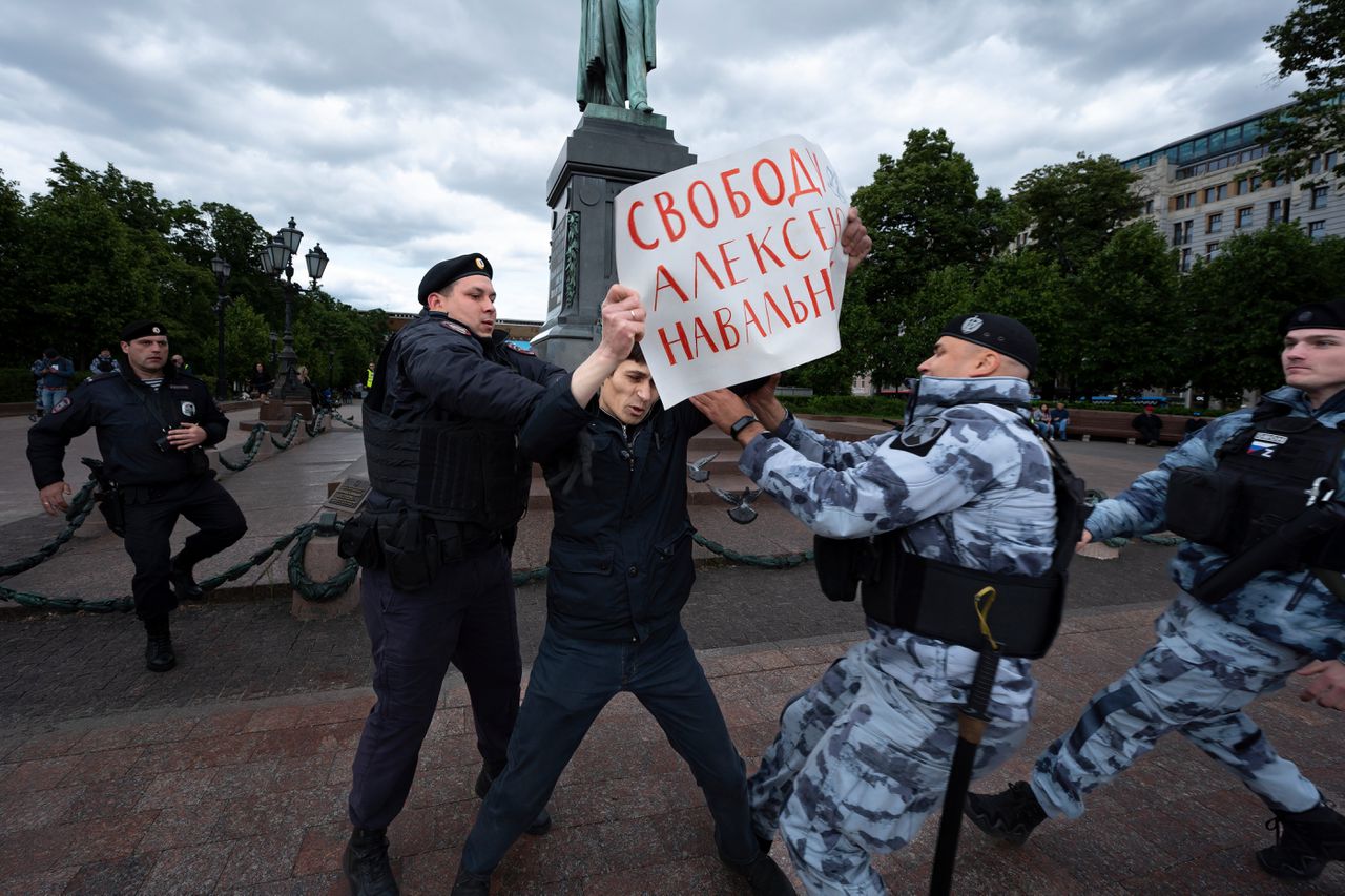 Een betoger wordt aangehouden door de politie in Moskou.