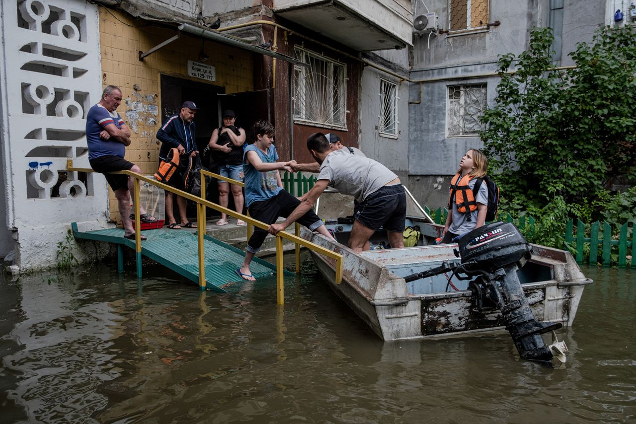 Bewoners van een gebouw in het overstroomde deel van Cherson worden woensdag geëvacueerd, na de verwoesting van de Nova Kachovka-stuwdam in de rivier de Dnipro.