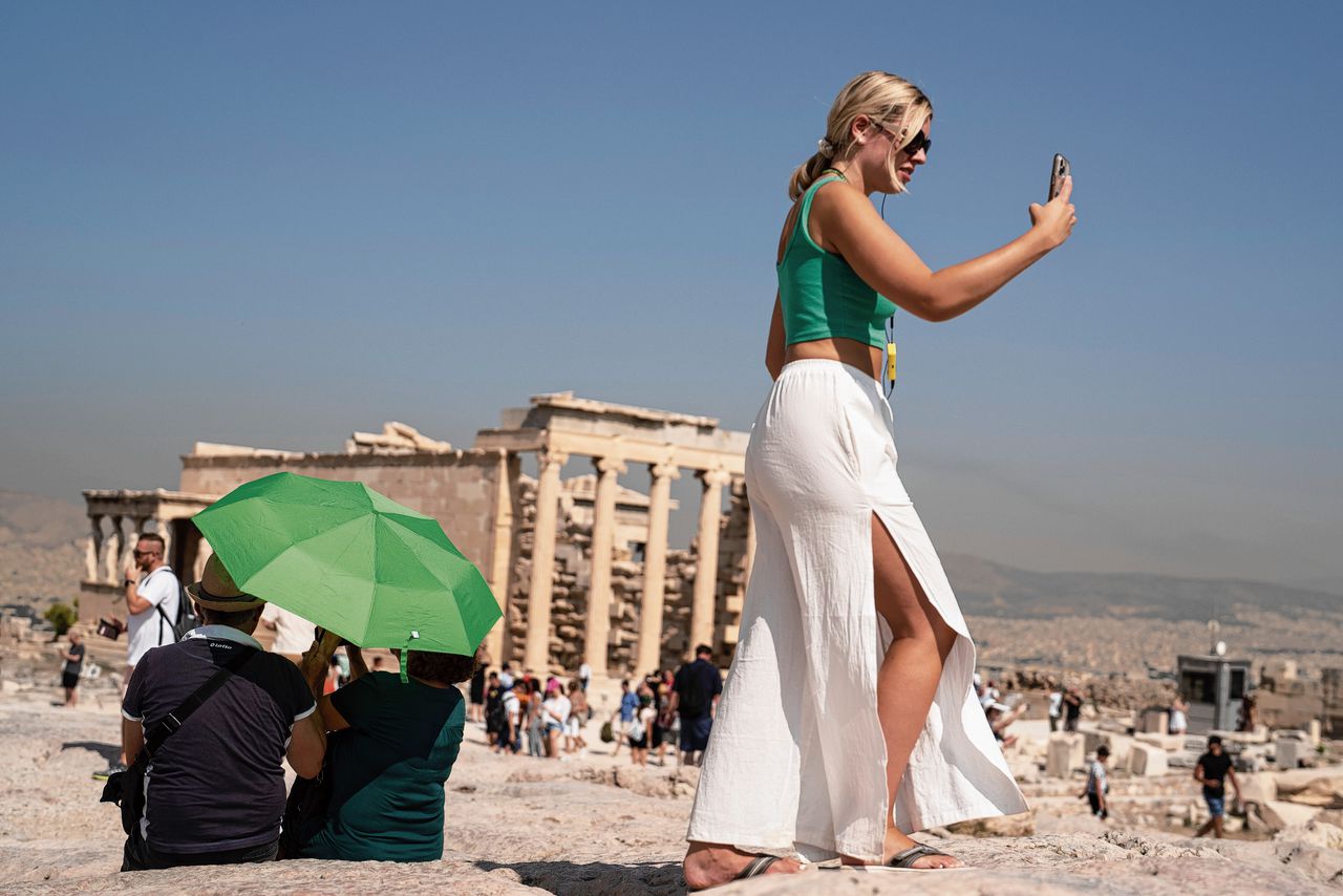 Een toerist maakt foto's bij de Akropolis in het Griekse Athene, die vorige week vanwege de hittegolf tijdens de heetste uren overdag gesloten werd.