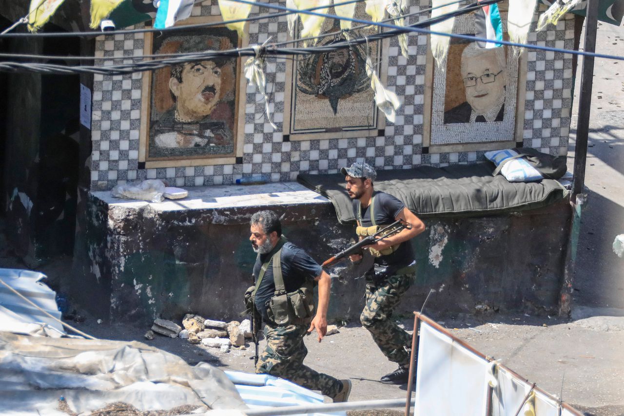 Leden van de Palestijnse Fatah-partij rennen door het kamp Ain al-Hilweh tijdens de derde dag van de gevechten.