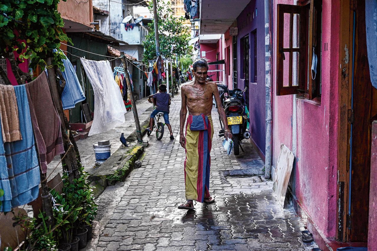 De gepensioneerde accountant Milton Perera voor en in zijn woning in Slave Island, een buitenwijk van Colombo. Hij behoort tot de velen in Sri Lanka die het hoofd maar net boven water konden houden tijdens de economische crisis die vorig jaar leidde tot het afzetten van president Gotabaya Rajapaksa.