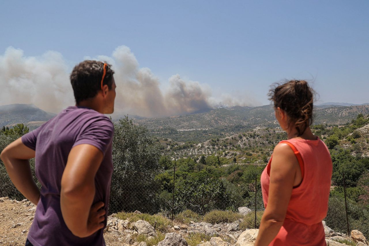 Twee Zwitserse toeristen kijken naar een bosbrand op Rhodos.