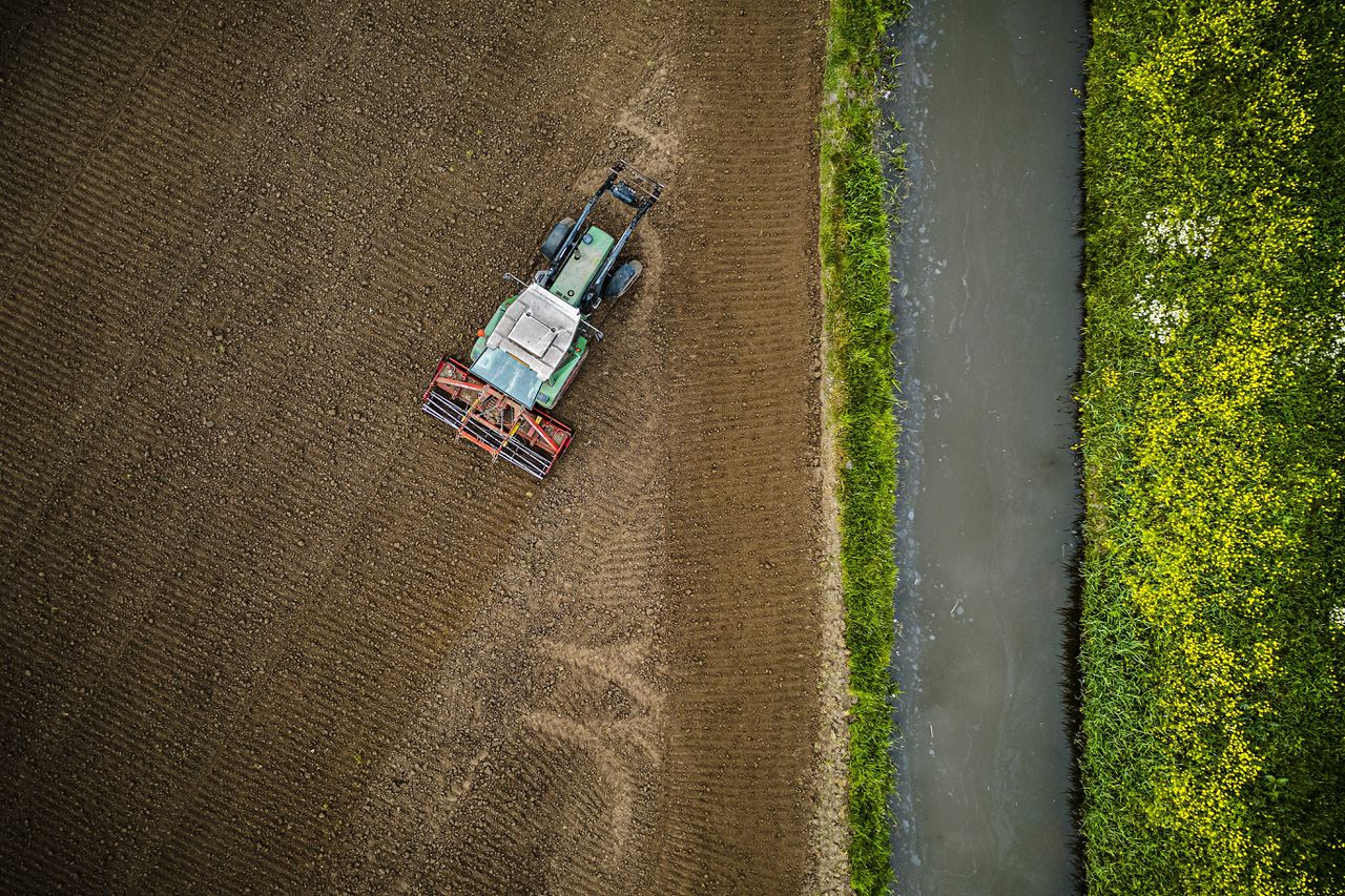 Een boer ploegt zijn akker in Raamsdonkveer. Het overgrote deel van de in de uitkoopregeling geïnteresseerde boeren betreft piekbelasters.