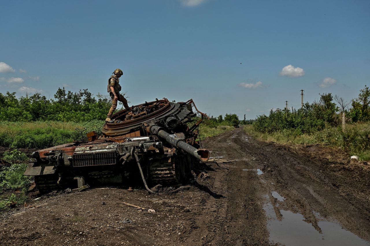 Een Oekraïense militair bij een Russische tank in de regio Zaporizja.