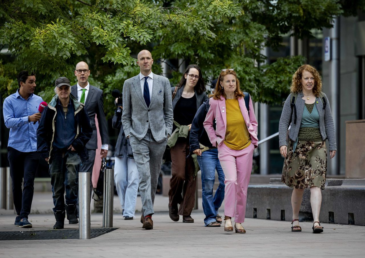 De acht gedaagden, waaronder acteur Sieger Sloot, voorafgaand aan hun zaak. De klimaatactivisten worden verdacht van opruiing.