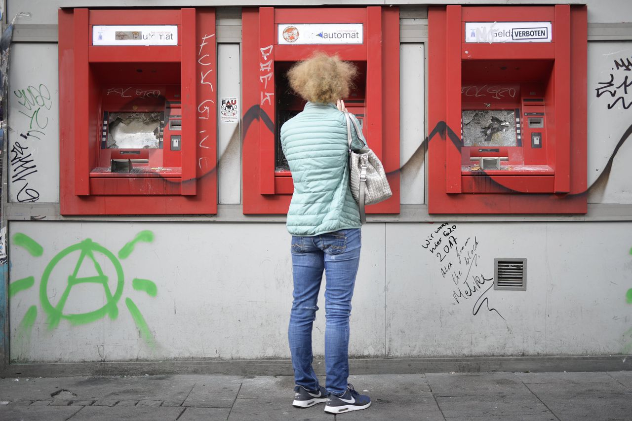 Een vrouw kijkt in Hamburg naar een rij opgeblazen pinautomaten.