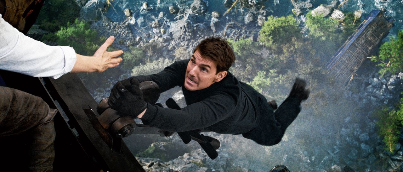 Tom Cruise hangt aan een treinwagon boven een afgrond in Mission: Impossible.